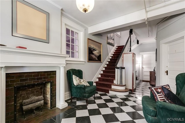 interior space featuring baseboards, dark floors, stairway, crown molding, and a fireplace