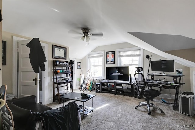 carpeted office space featuring vaulted ceiling and a ceiling fan