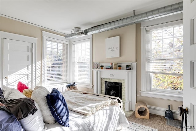 bedroom with multiple windows, a fireplace, and baseboards