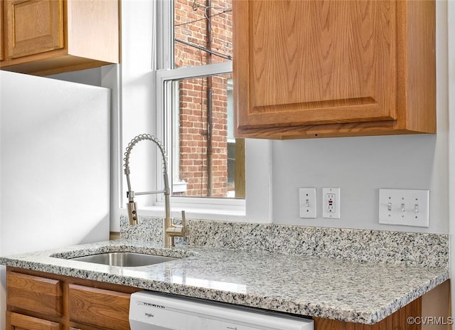 room details featuring dishwasher, light stone counters, and a sink