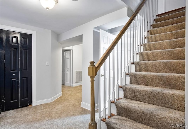 staircase featuring carpet, visible vents, and baseboards