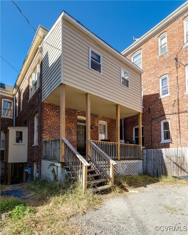 view of front of house with a porch and brick siding