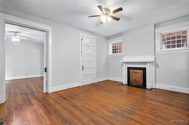 unfurnished living room with a ceiling fan, baseboards, and wood finished floors