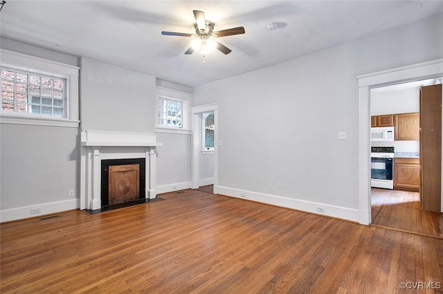 unfurnished living room with a ceiling fan, a fireplace with flush hearth, baseboards, and hardwood / wood-style floors