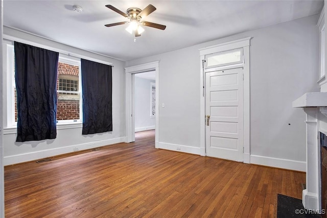 unfurnished living room featuring a fireplace with flush hearth, baseboards, ceiling fan, and hardwood / wood-style floors