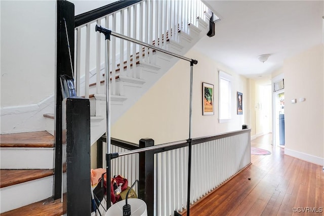 staircase featuring wood-type flooring and baseboards