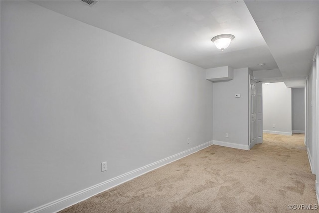 spare room featuring baseboards and light colored carpet