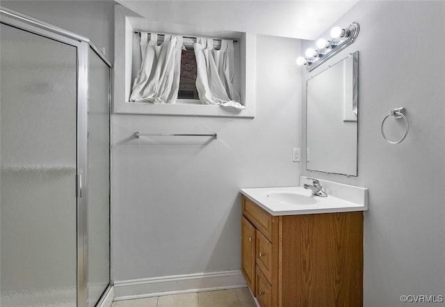 bathroom with a stall shower, baseboards, and vanity