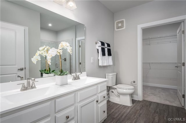 bathroom featuring tiled shower, a sink, visible vents, and wood finished floors