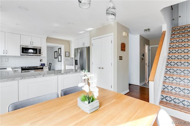 dining room featuring stairway, baseboards, and dark wood-style flooring