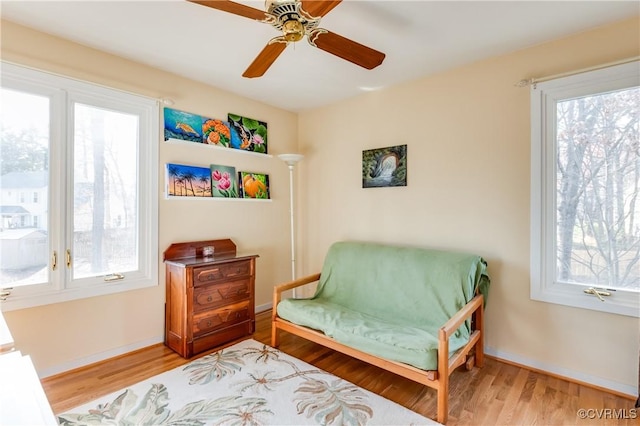 sitting room featuring wood finished floors, baseboards, and a wealth of natural light