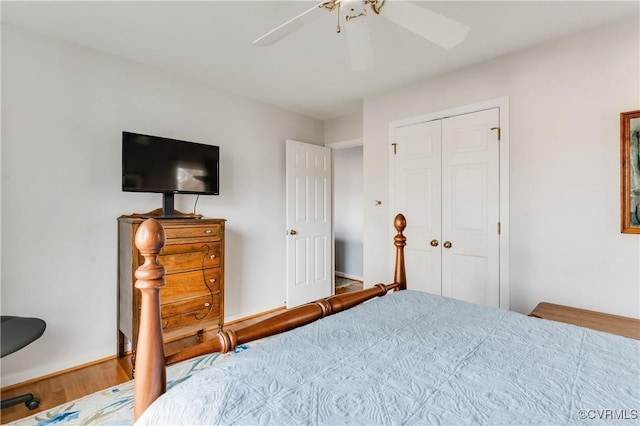 bedroom featuring a ceiling fan, wood finished floors, a closet, and baseboards