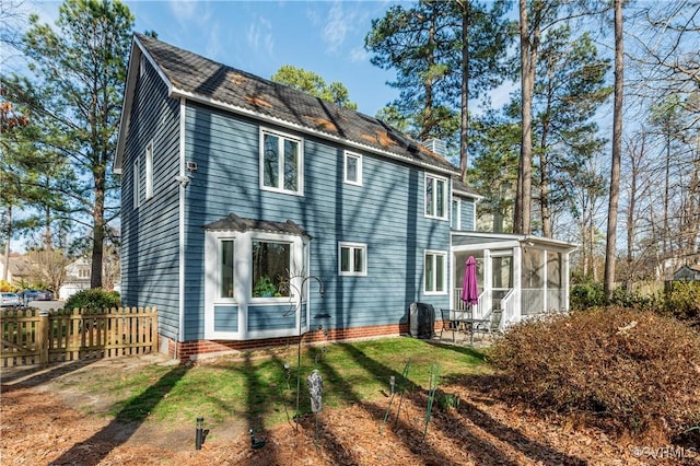 back of property with a patio, fence, a lawn, and a sunroom