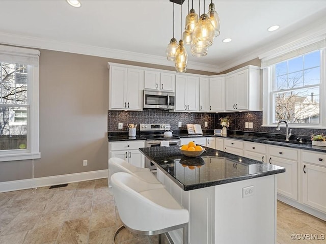 kitchen with appliances with stainless steel finishes, crown molding, a sink, and tasteful backsplash