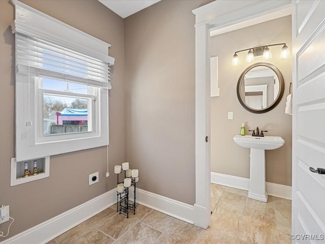 bathroom with a sink and baseboards