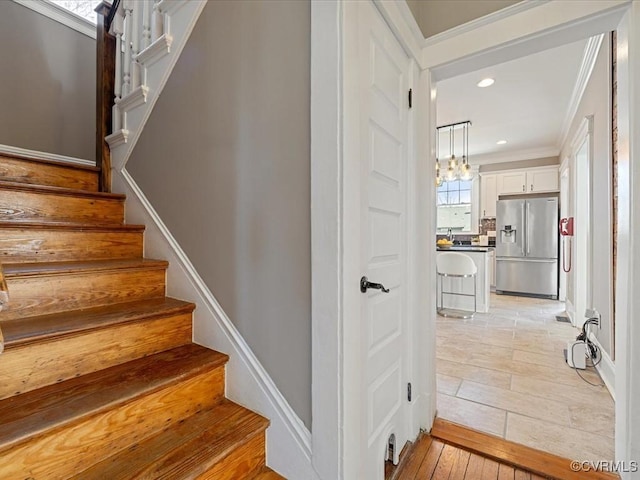 staircase with crown molding, wood finished floors, and recessed lighting