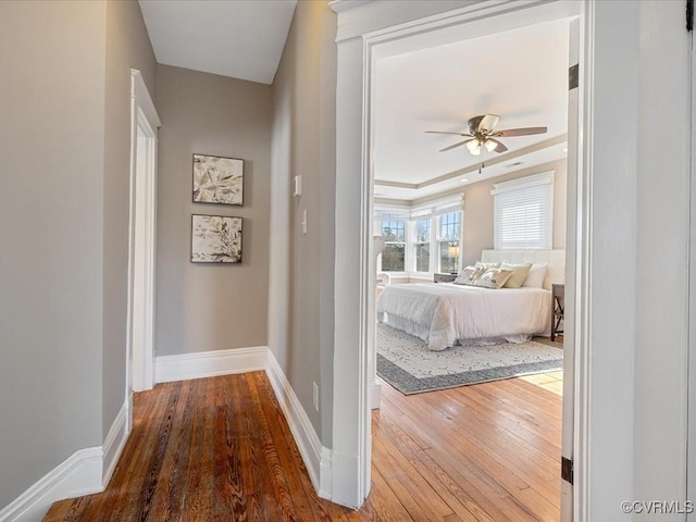 corridor featuring hardwood / wood-style flooring and baseboards