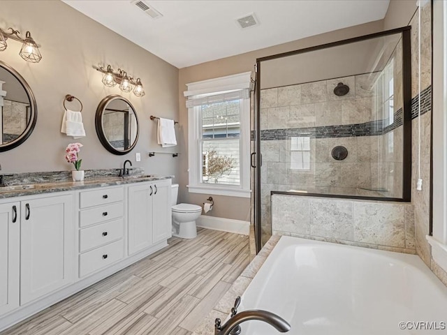 bathroom with toilet, a washtub, a sink, visible vents, and tiled shower