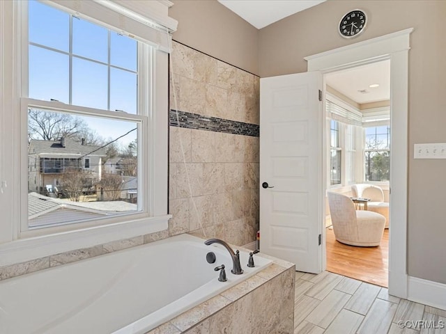 full bath with wood finished floors and a garden tub