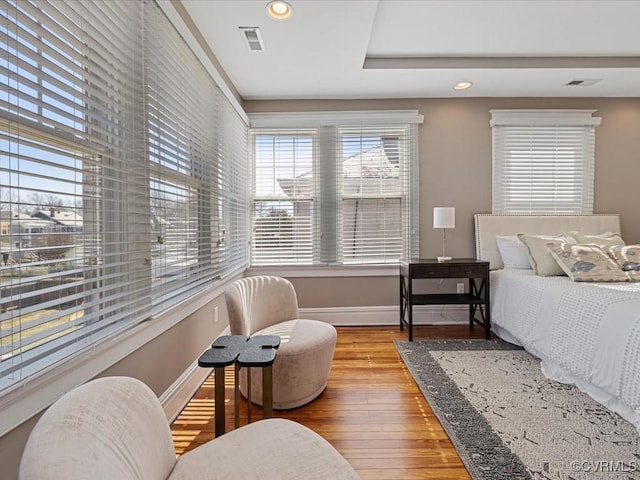 bedroom with hardwood / wood-style flooring, recessed lighting, visible vents, and baseboards