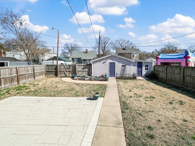 view of yard with an outbuilding, a patio, and a fenced backyard