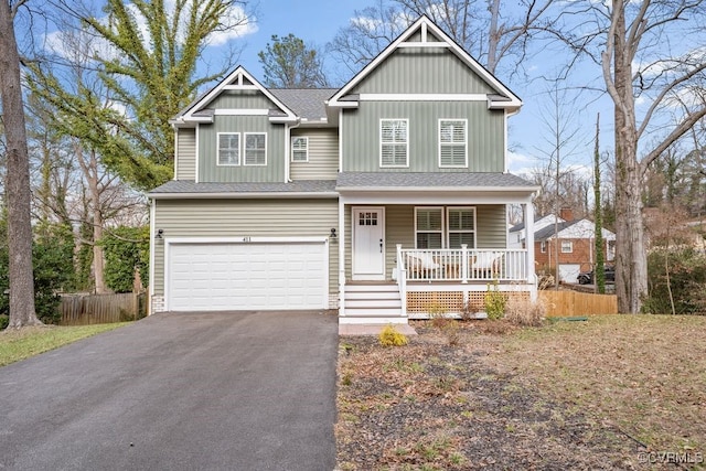 view of front of home featuring roof with shingles, covered porch, fence, a garage, and driveway