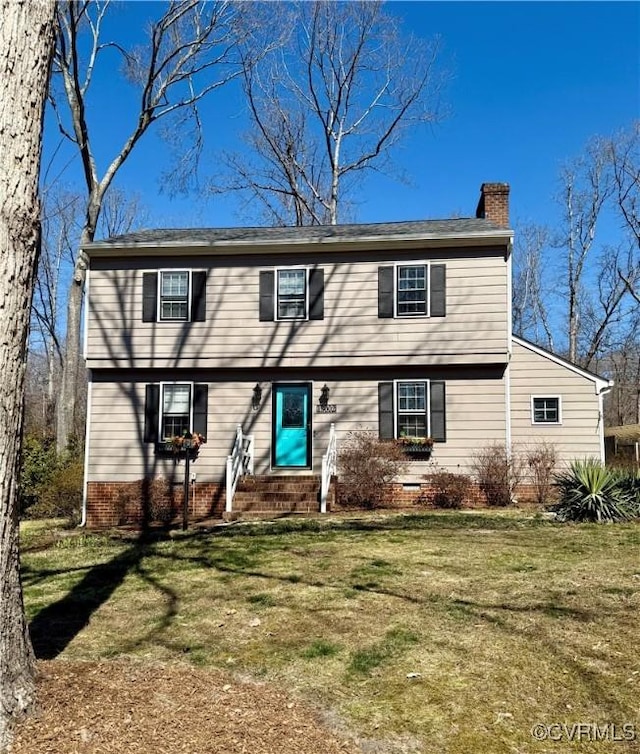 colonial inspired home with crawl space, entry steps, a chimney, and a front yard