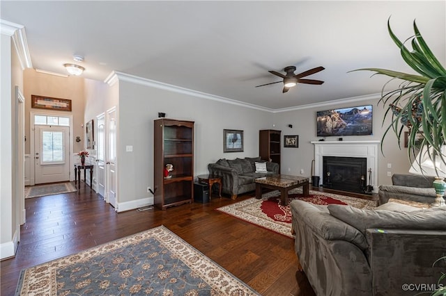 living area featuring ornamental molding, dark wood-style flooring, a fireplace with flush hearth, and baseboards