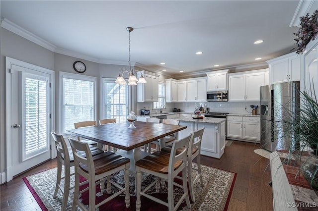 dining room featuring ornamental molding, dark wood-style flooring, recessed lighting, and an inviting chandelier