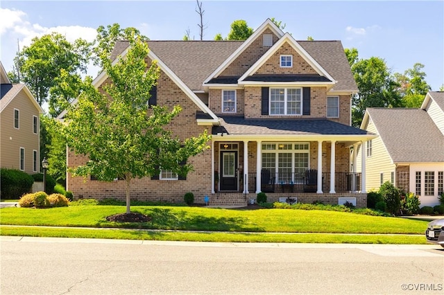 craftsman-style house with brick siding, covered porch, and a front yard