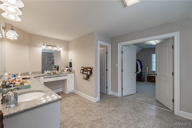 bathroom with double vanity, baseboards, walk in shower, and a sink