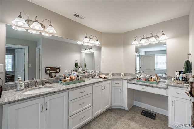 full bath featuring double vanity, tile patterned flooring, visible vents, and a sink