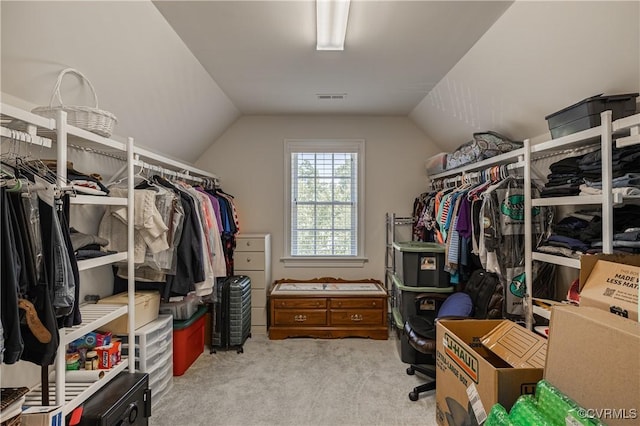 walk in closet with carpet floors, lofted ceiling, and visible vents