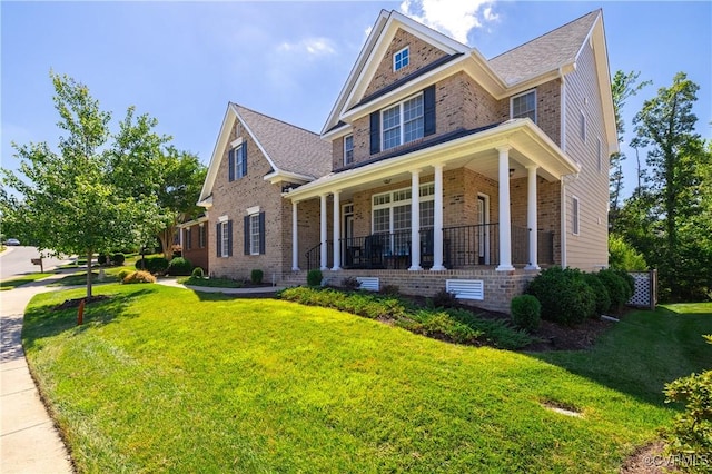 view of front of home with brick siding, a porch, and a front yard