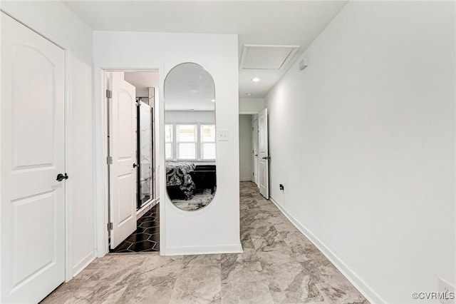 corridor with attic access, baseboards, and marble finish floor