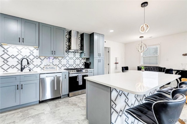 kitchen with wall chimney range hood, light countertops, a kitchen breakfast bar, marble finish floor, and stainless steel appliances