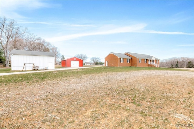 view of yard with a garage, an outdoor structure, and driveway