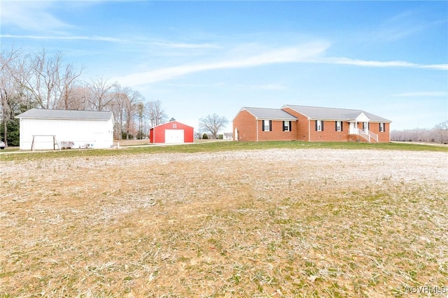 view of yard featuring an outbuilding, a detached garage, and a pole building