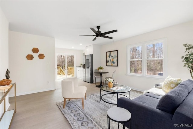 living room with a ceiling fan, recessed lighting, light wood-style flooring, and baseboards