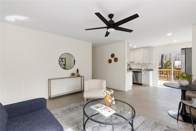 living area with light wood finished floors, baseboards, a ceiling fan, and recessed lighting