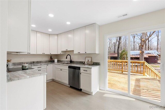 kitchen featuring visible vents, white cabinets, black electric stovetop, stainless steel dishwasher, and a sink