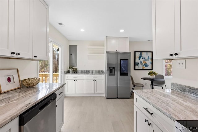 kitchen with appliances with stainless steel finishes, a wealth of natural light, and light stone countertops