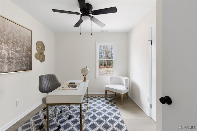 office space featuring ceiling fan, baseboards, and wood finished floors