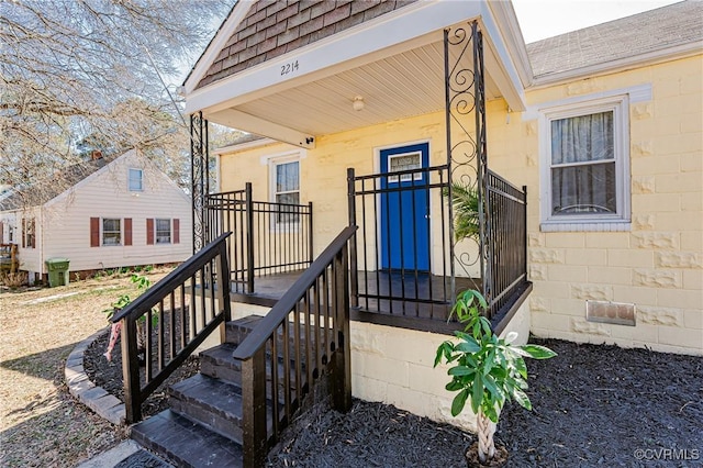 doorway to property with roof with shingles