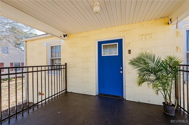 entrance to property featuring a balcony and concrete block siding