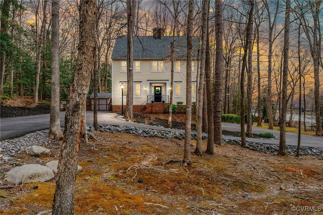 view of front of house featuring a shingled roof and a chimney