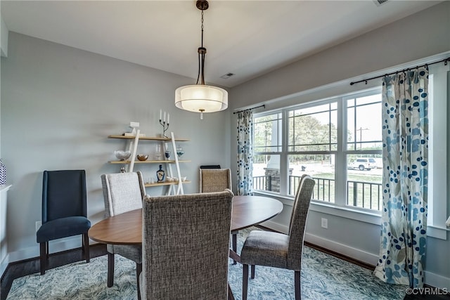 dining room featuring wood finished floors, visible vents, and baseboards