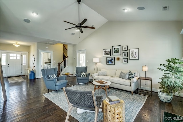 living area with dark wood-style floors, visible vents, baseboards, and stairs