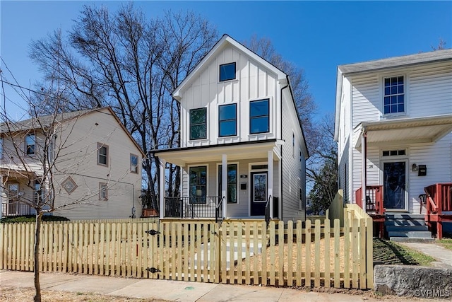 view of front of house featuring a porch, board and batten siding, a gate, and a fenced front yard