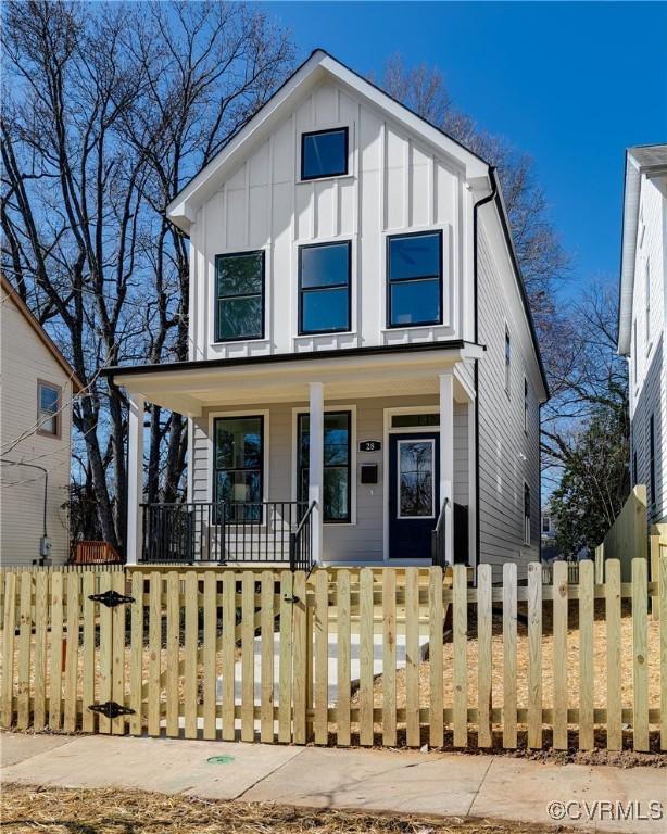 view of front of house featuring board and batten siding, a porch, and a fenced front yard